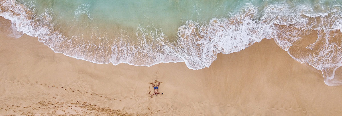 Vue de drône au-dessus d'un homme couché sur une plage